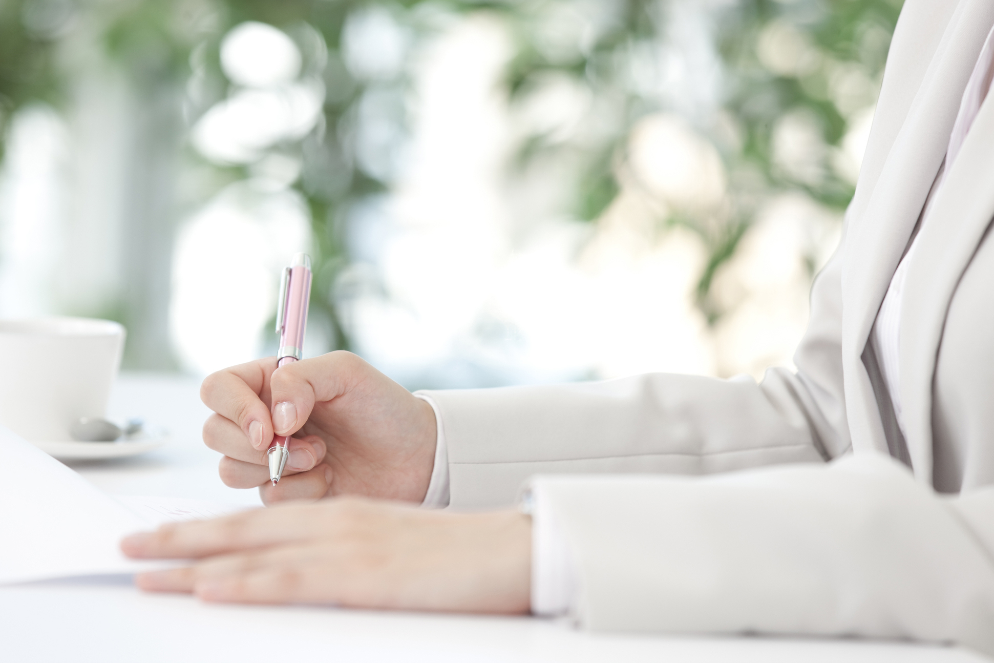 ペンを握る女性の手元